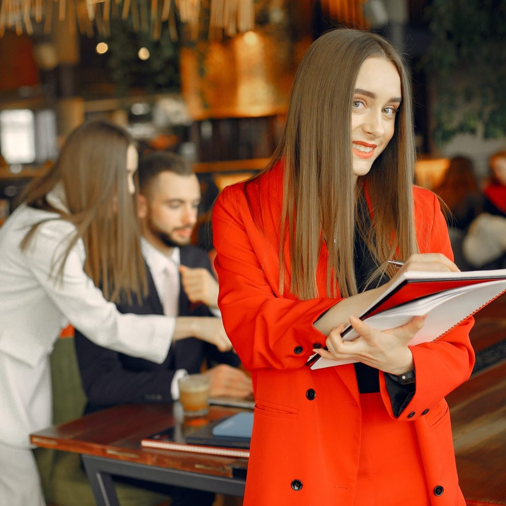Man and two beautiful women working. People in a cafe. Women in a elegant suit cases